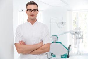Female dentist standing with his hands crossed and looking at camera