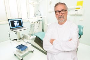 Senior dentist standing at her office